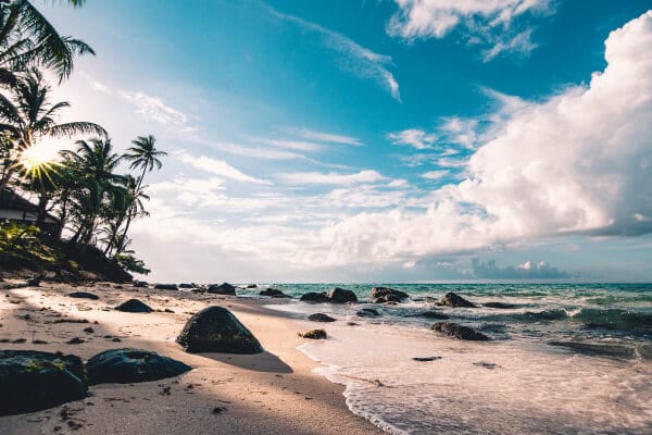 View from the beach, looking over the sands of Playa Potrero to the waters of the Pacific Ocean with a clear blue sky above.